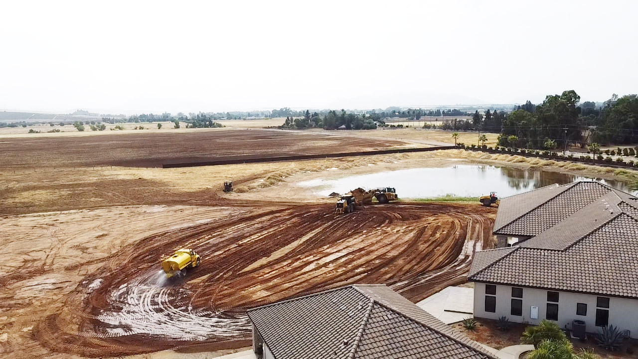Image of earthwork machines grading a residential backyard